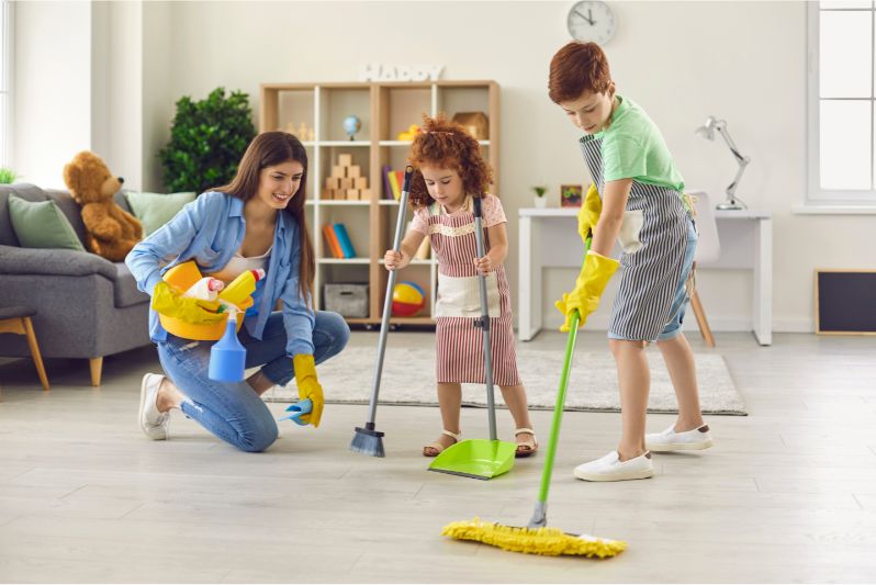 menino (7 anos) e menina (5 anos) ajudam mãe em pequenas tarefas domésticas - a limpar chão